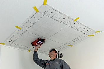 Рабочий, проводящий неразрушающий контроль потолка