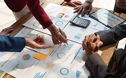 Изображение коллег по бизнесу, которые обсуждают финансовую статистику и графики