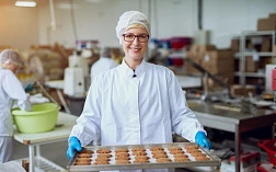 изображение работника на пищевом предприятии, который держит поднос