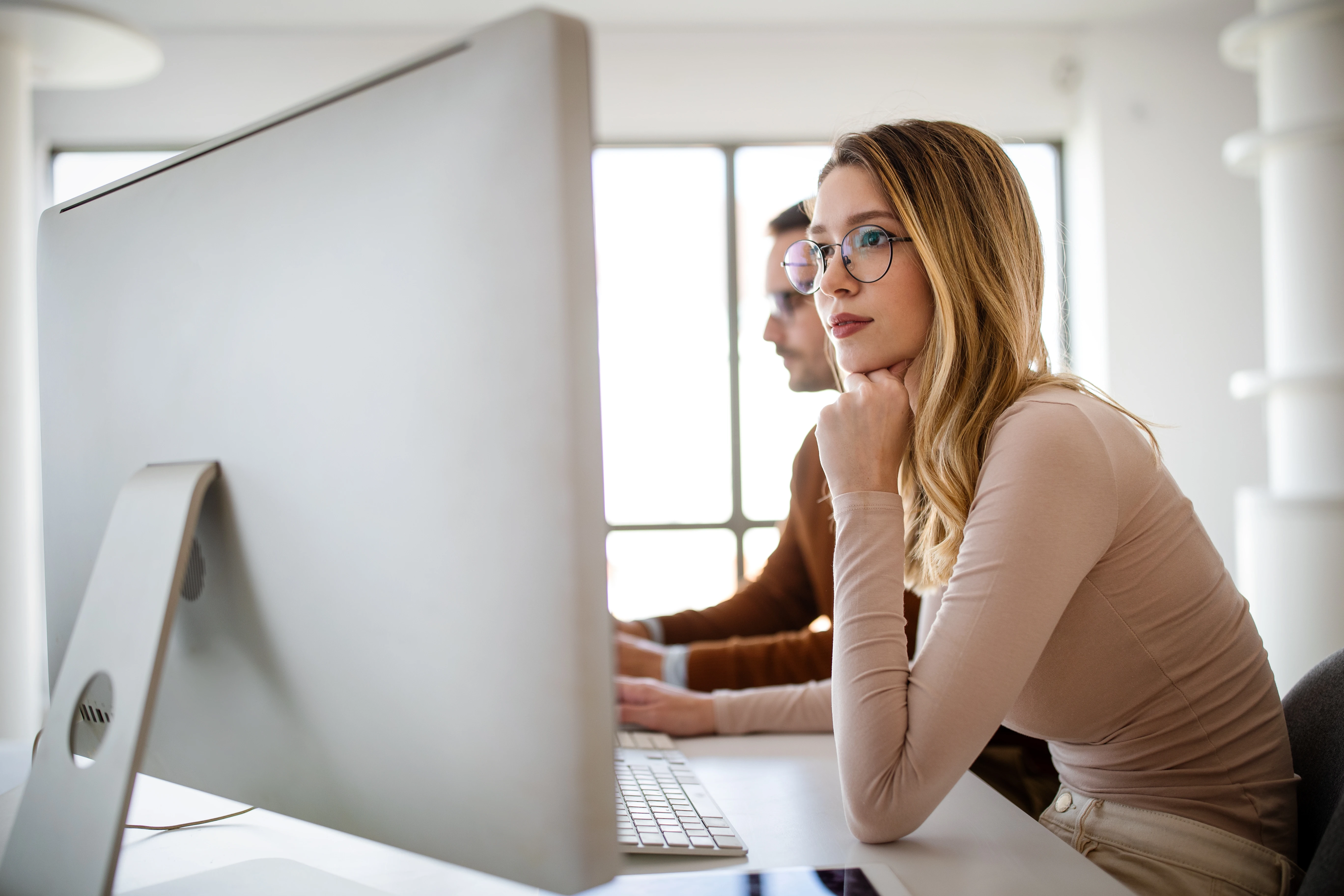 Девушка работает в офисе за компьютером